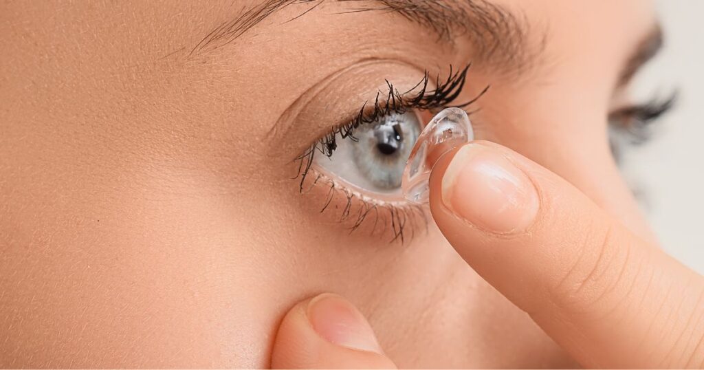 woman putting lens in eye